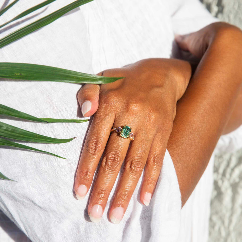 Premium Photo | A fancy green emerald is set in a gold ring with diamonds  around it.